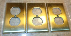 3 Vintage Brass Electrical Outlet Covers With Scratches And Worn Spots